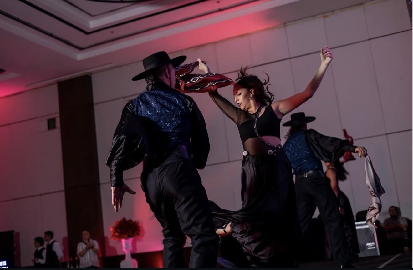 Actuación de baile con varios intérpretes y vestuario negro en salón: Harmony Buenos Aires.
