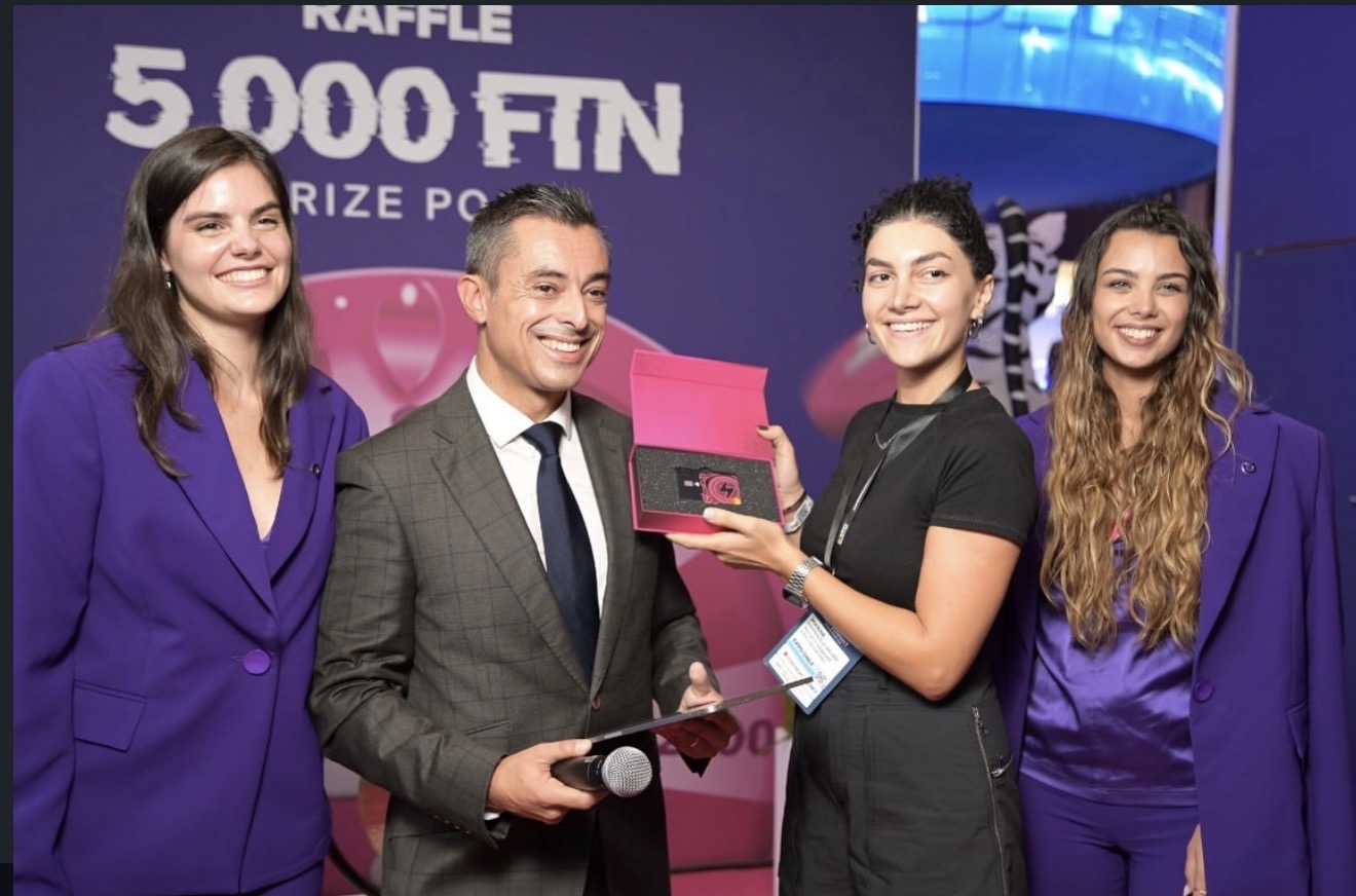 Presentador de sorteo con micrófono y equipo junto a un participante mostrando un premio. SBC Lisboa 2025.